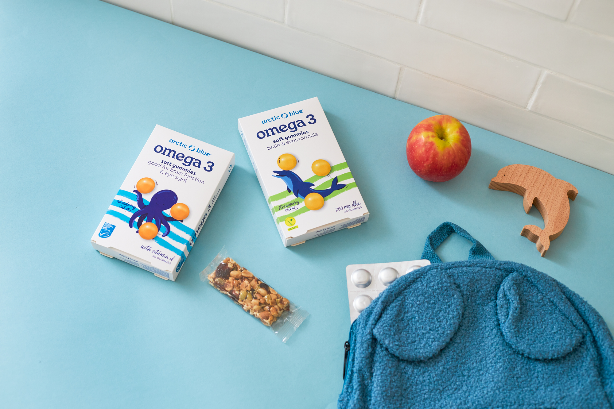 Arctic blue gummies on table with a school bag and apple